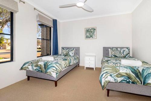 a bedroom with two beds and a ceiling fan at Meters to Beach, Walk to Town! in Quindalup