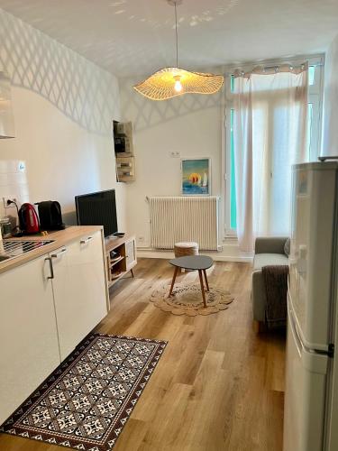 Il dispose d'une cuisine et d'un salon avec un réfrigérateur et une table. dans l'établissement Bel appart fonctionnel et lumineux en centre ville, clinique et Tram à 5 mn, situation idéale !, à Castelnau-le-Lez