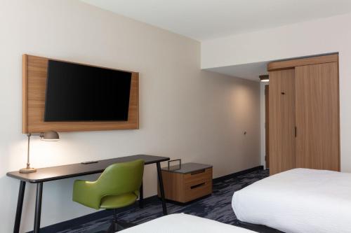 a hotel room with a desk and a tv at Fairfield by Marriott Inn & Suites Omaha at MH Landing in Omaha