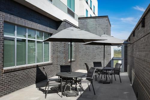 two tables and chairs with umbrellas on a patio at Fairfield by Marriott Inn & Suites Omaha at MH Landing in Omaha