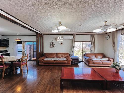 a living room with leather couches and a table at 那須別荘 那須エデン in Nasu