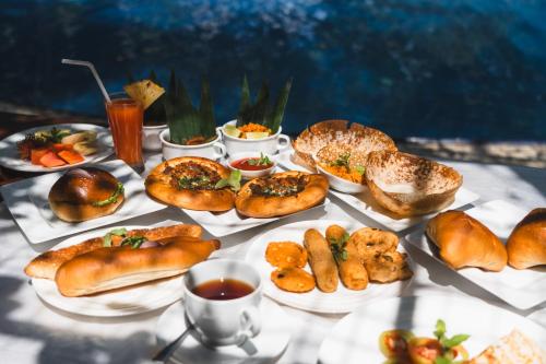 a table topped with different types of bread and pastries at Sundaras Resort LTD in Dambulla