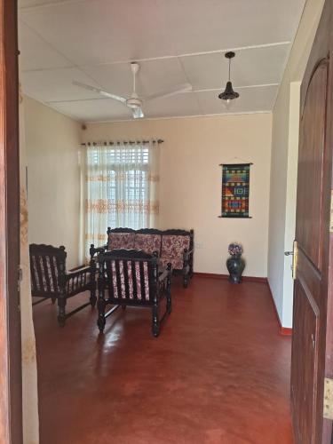 a living room with two chairs and a couch at Ransini Holiday Home in Ambalangoda