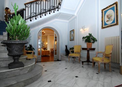 a living room with a staircase and a table and chairs at Grande Albergo Quattro Stagioni in Rieti