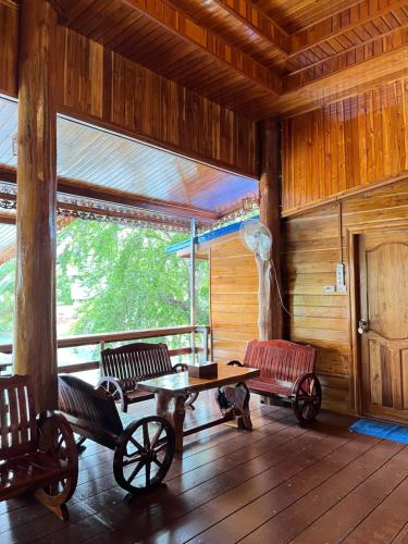 a room with benches and a table in a cabin at ห้างหุ้นส่วนจำกัด บ้านเถ้าแก่ in Ban Muang Baeng