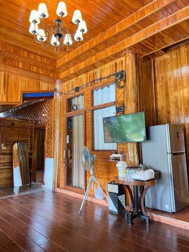 a living room with a refrigerator and a table at ห้างหุ้นส่วนจำกัด บ้านเถ้าแก่ in Ban Muang Baeng