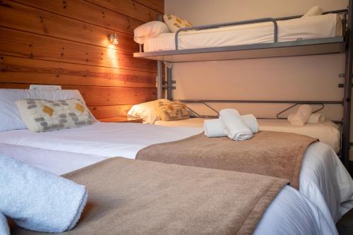 two beds in a room with two bunk beds at Hotel Restaurant Les Brases in Sort