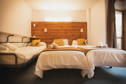 two beds in a bedroom with a headboard at Hotel Restaurant Les Brases in Sort