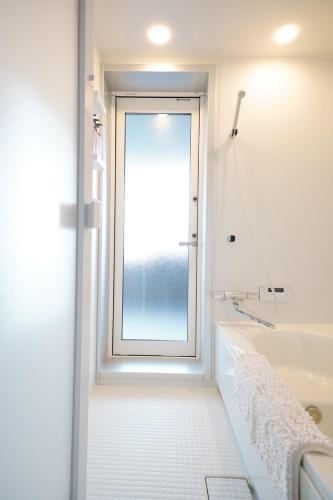 a bathroom with a window and a bath tub at Glee Niseko LUX condo 羊蹄山一望 新築 駐車場完備 in Kutchan