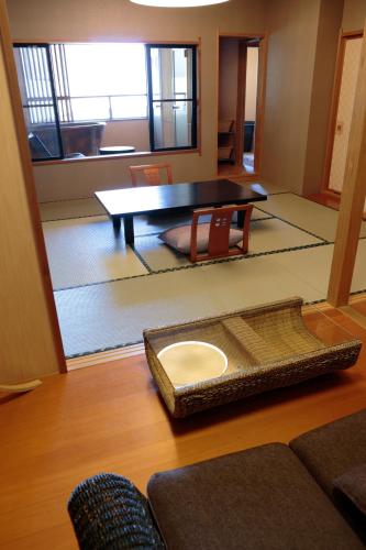 a living room with a table and chairs at Inatori Akao Hotel in Higashiizu