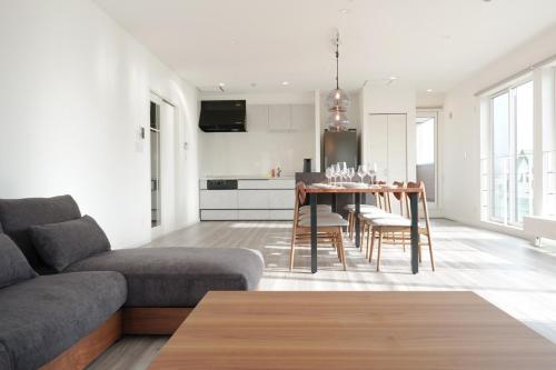 a living room with a couch and a table at Glee Niseko LUX condo 羊蹄山一望 新築 駐車場完備 in Kutchan