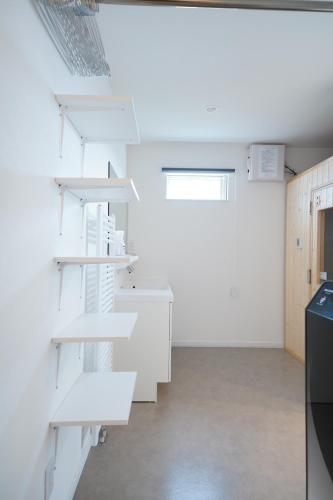 a kitchen with white shelves in a room at Glee Niseko LUX condo 羊蹄山一望 新築 駐車場完備 in Kutchan