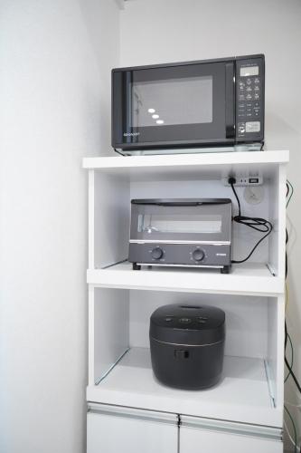 a microwave and a printer on a white shelf at Glee Niseko LUX condo 羊蹄山一望 新築 駐車場完備 in Kutchan