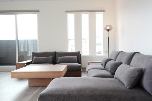 a living room with a couch and a coffee table at Glee Niseko LUX condo 羊蹄山一望 新築 駐車場完備 in Kutchan