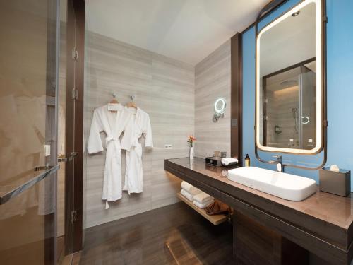 a bathroom with a sink and a mirror at 成都中航明宇尚雅酒店 in Xindu