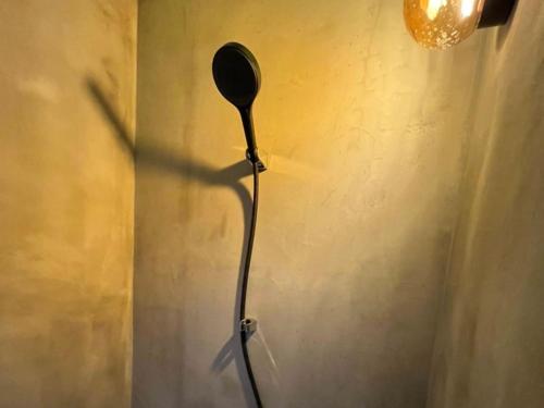 a black floor lamp is on a wall at Negura in Ujimi