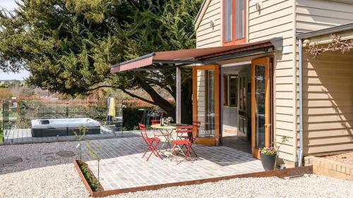 a house with a patio with a table and chairs at Clergy Cottage in Taradale