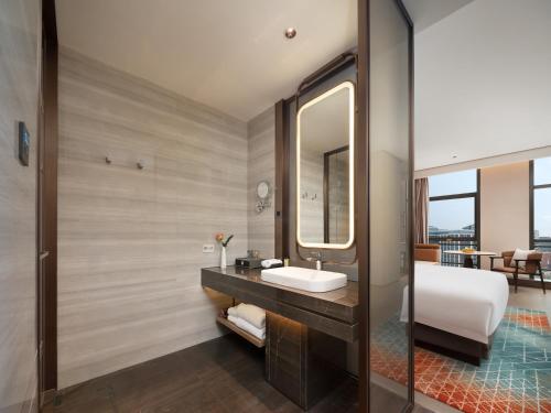 a bathroom with a sink and a mirror at 成都中航明宇尚雅酒店 in Xindu