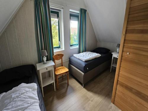 a small bedroom with a bed and a small table at Modern Beach Retreat Sauna in Breskens