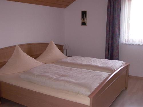 a bed with white sheets and pillows in a bedroom at Ferienwohnungen Meindl in Lam