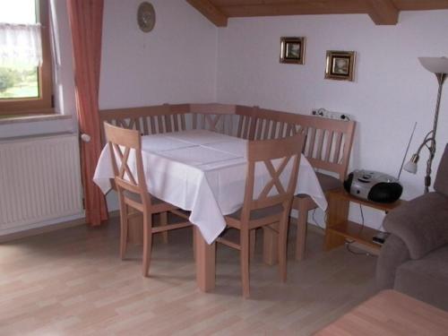 a dining room table with a white table cloth on it at Ferienwohnungen Meindl in Lam