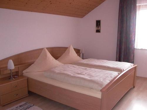 a bedroom with a large bed with a wooden headboard at Ferienwohnungen Meindl in Lam