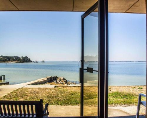 a view of the water through a glass door at Quality Inn & Suites Gulf Breeze Bayside near Pensacola Beach in Gulf Breeze