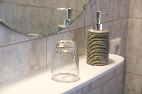 a bathroom sink with a soap dispenser and a mirror at Kreilingshöfchen Apartments in Bad Vilbel