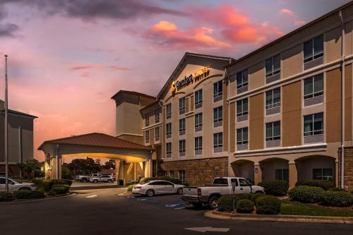 a hotel with cars parked in a parking lot at Comfort Suites Valdosta Mall Area in Valdosta