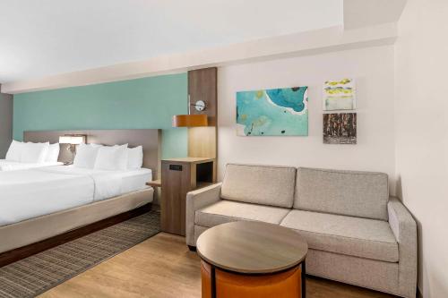 a hotel room with a bed and a couch at Comfort Suites Valdosta Mall Area in Valdosta