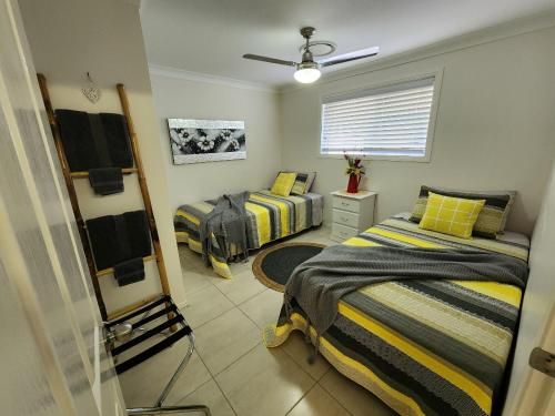 a bedroom with two beds and a mirror at Jubri's Hideaway in Dalby