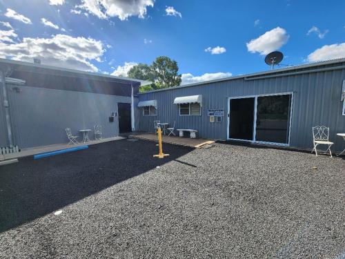 a building with a parking lot next to a garage at Jubri's Hideaway in Dalby