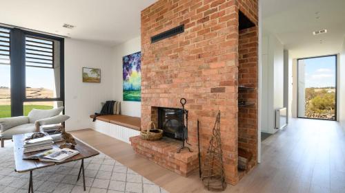 a living room with a brick fireplace and a couch at Fassway Farm in Edgecombe