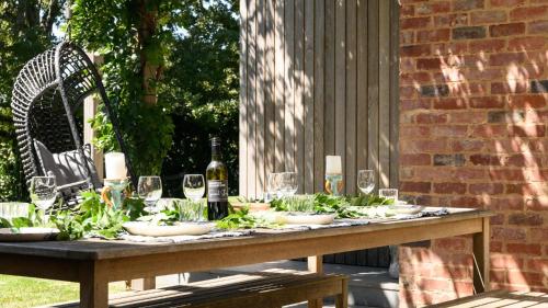 a table with wine glasses and greens on it at Fassway Farm in Edgecombe