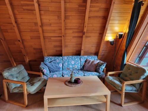 a living room with a couch and two chairs and a table at Chaty Kaszubskie in Łąkie