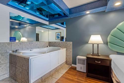 a bathroom with a tub and a bed at Atlantis Family Waterpark Hotel, an Ascend Collection Hotel in Wisconsin Dells