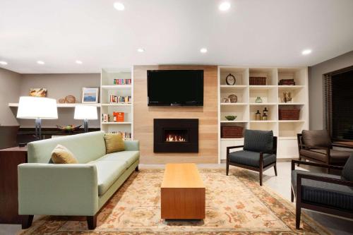 a living room with a couch and a fireplace at Country Inn & Suites by Radisson Roseville - St Paul in Roseville