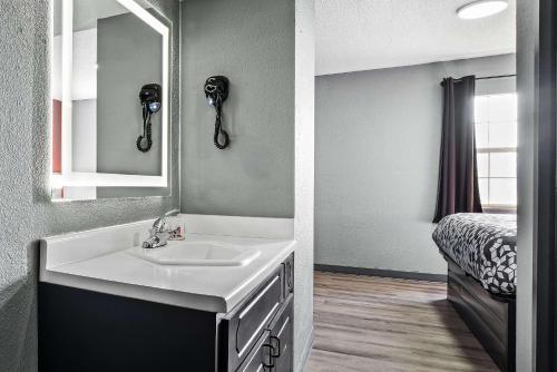 a bathroom with a sink and a mirror at Econo Lodge Kennett in Kennett