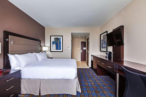 a hotel room with a large bed and a desk at Clarion Hotel The Colony - Plano West in The Colony