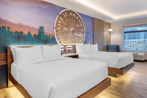 a hotel room with two beds and a large wheel mural at Cambria Hotel Pigeon Forge in Pigeon Forge