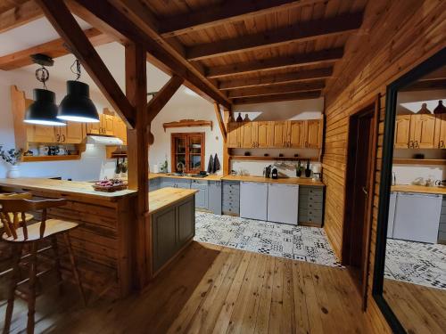 a kitchen with wooden floors and wooden ceilings at Chaty Kaszubskie in Łąkie