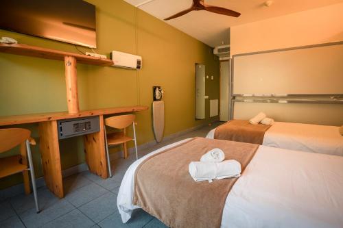 a hotel room with two beds and a desk at Hotel Restaurant Les Brases in Sort