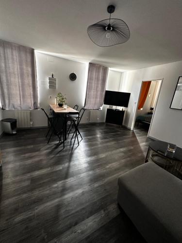 a living room with a table and chairs in it at Appart cocooning in Saint-Germain-des-Fossés