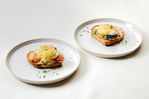 two plates of food on a white table at Relais&Châteaux Spa-Hotel Jagdhof in Neustift im Stubaital
