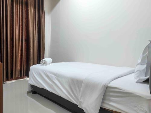 a bedroom with a bed with a alarm clock on it at Big and Comfy 3BR at Vida View Apartement By Travelio in Pampang