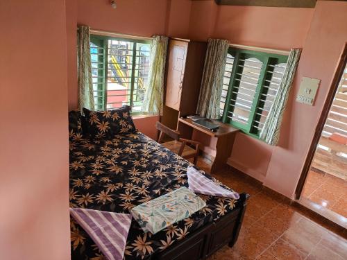 una camera da letto con un letto e due finestre di Tiny Temple a Varkala