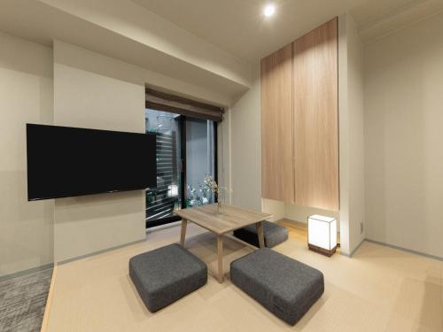 a living room with a table and a flat screen tv at Minn Kiyomizu Gojo in Kyoto