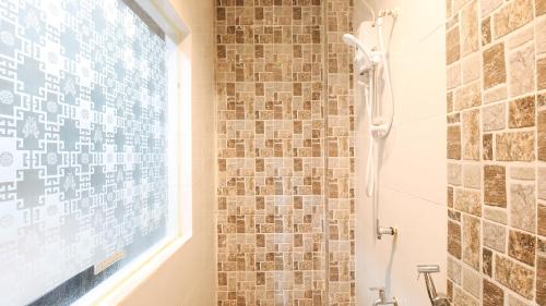 a bathroom with a shower and a glass window at RedDoorz @ P Florentino Street Sampaloc Manila in Manila