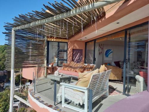 a patio with a chair and a table on a balcony at Absolute Beach Accommodation in Stompneusbaai