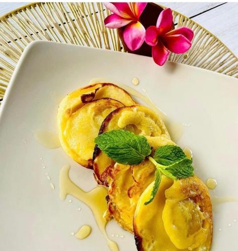 Un plato blanco con comida sobre una mesa. en Oasis Boutique Villas, en Nusa Lembongan